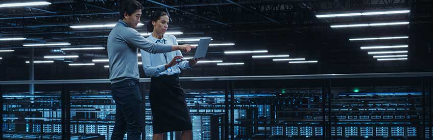 Data Center Female System Administrator and Male IT Specialist Talk, Use Laptop Computer.