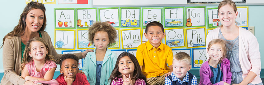 Teacher with class and Teacher's Assistant smiling