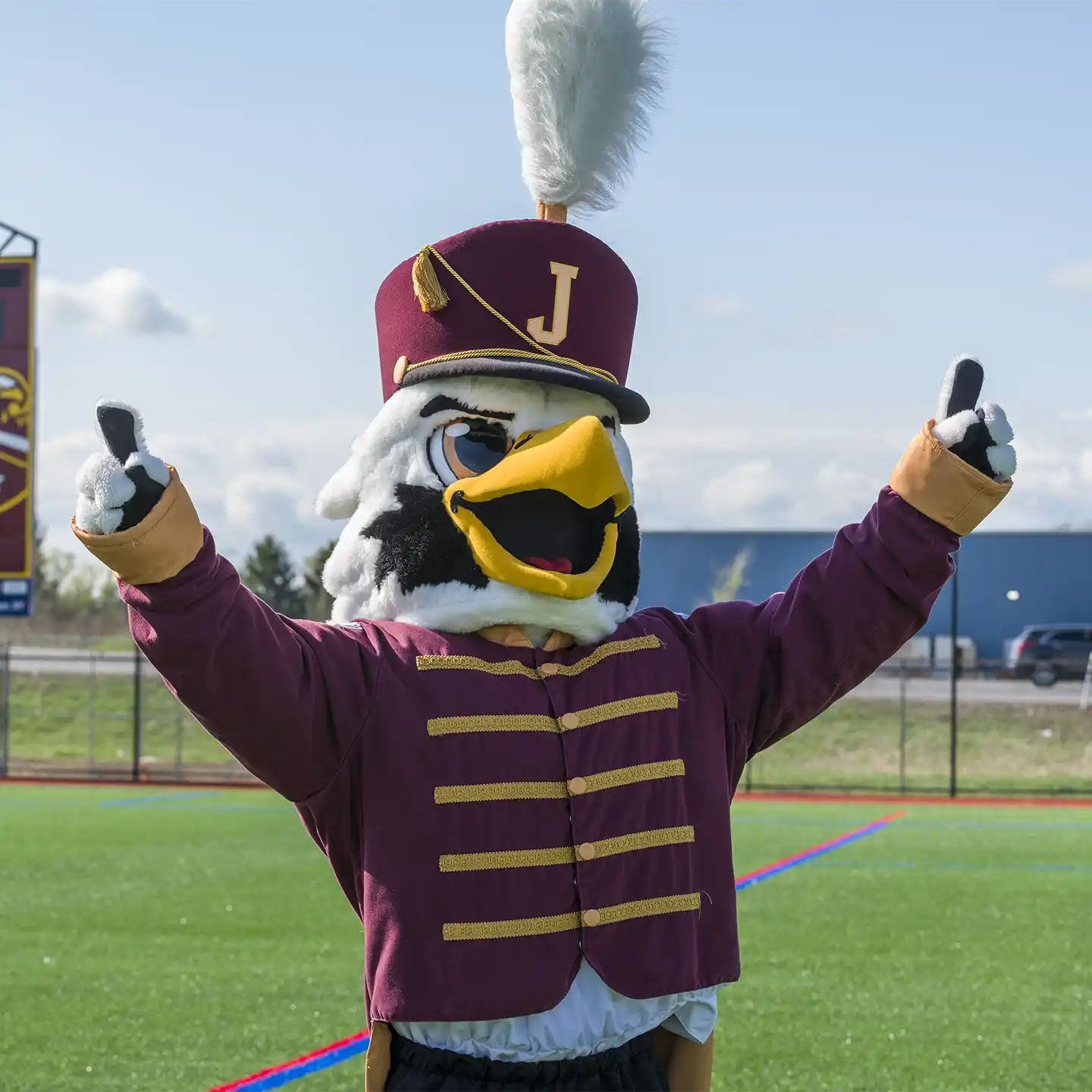 JCC Mascot Boomer T. Cannoneer with arms pointing to the sky