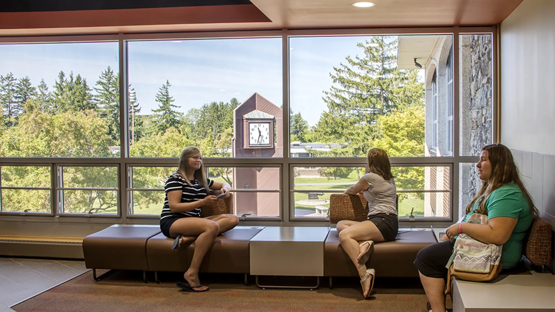 Group of students on campus looking out window at clock tower.