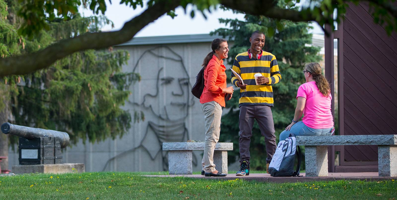 Three students conversing on campus